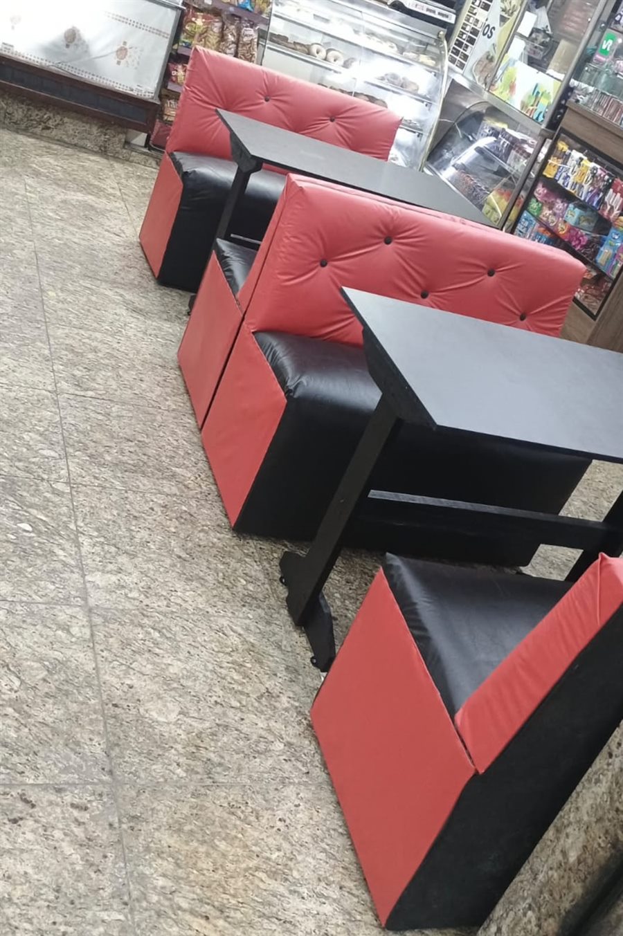 Sofás booth vermelho e preto com mesas pretas